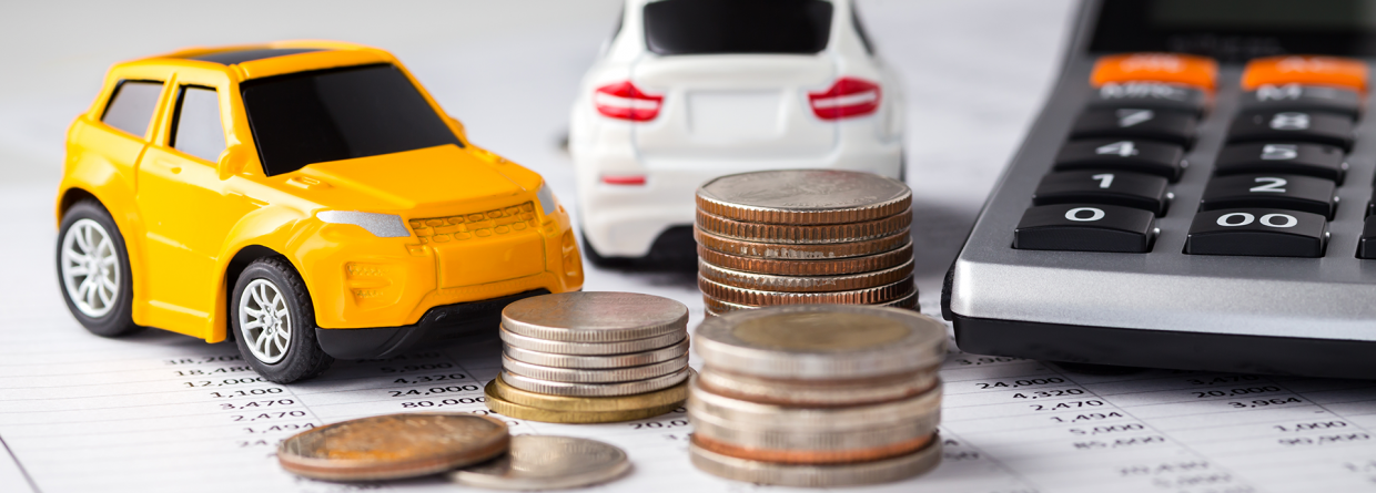 En gele en witte kleine speelgoedauto op een papier met een stapel munten en een rekenmachine